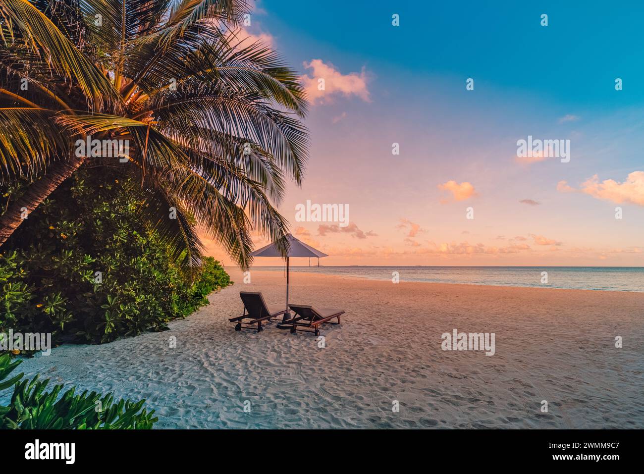 Plage tranquille de sable de mer coucher de soleil ciel de détente. Couple d'amour concept de paysage de voyage de liberté romantique. Chaises exotiques idylliques parasol, feuilles de palmier Banque D'Images