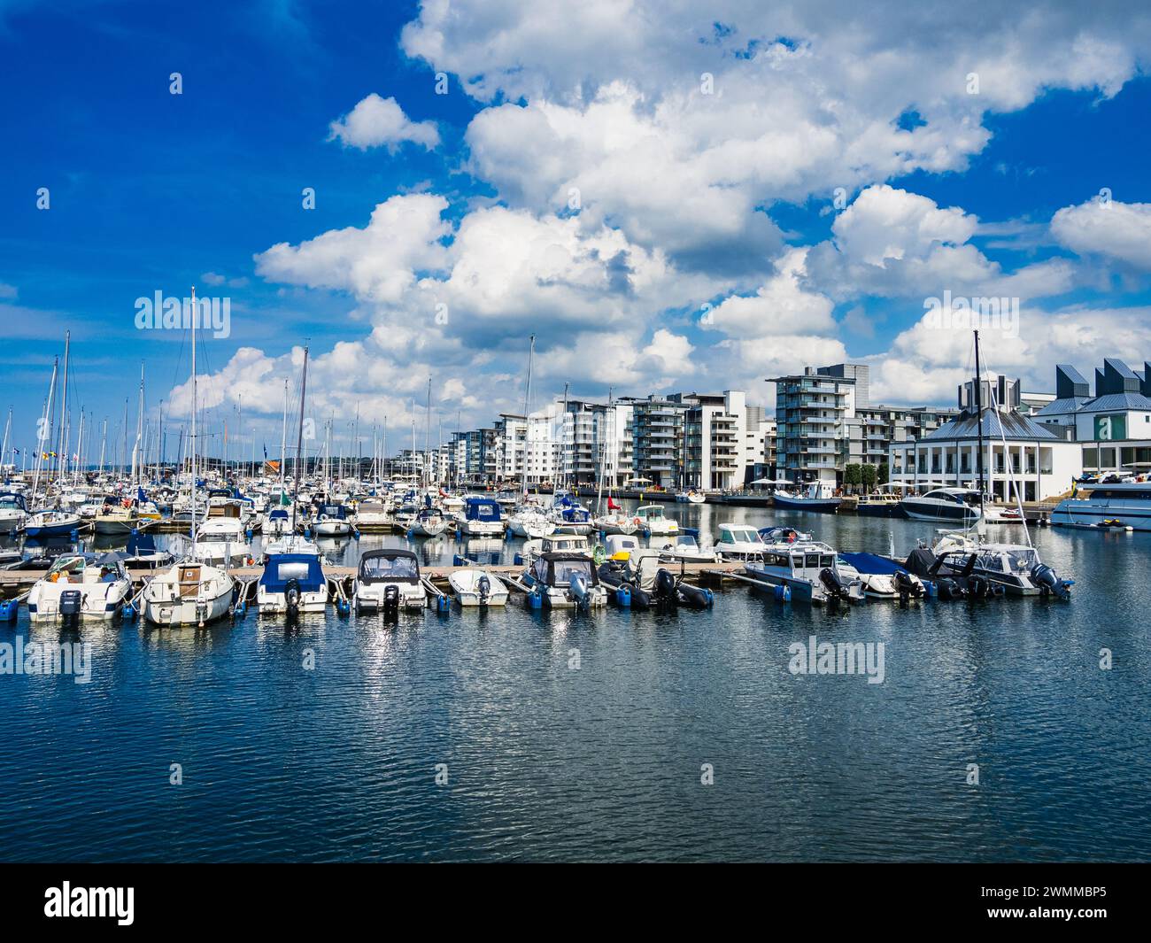 Le port animé de Helsingborg en Suède est animé par des rangées de bateaux amarrés par une belle journée d'été. L'eau tranquille reflète le ciel bleu clair Banque D'Images