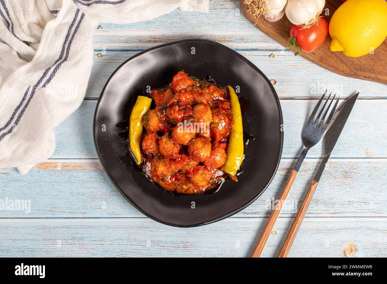 Boulettes de viande d'Alep. Hors-d'œuvre. Petites boulettes de viande avec de la pâte de tomate sur un fond en bois bleu. Vue de dessus Banque D'Images