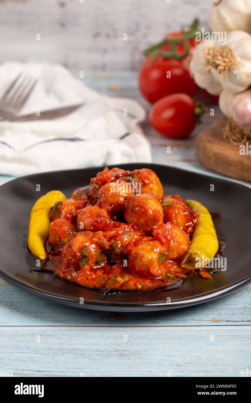 Boulettes de viande d'Alep. Hors-d'œuvre. Petites boulettes de viande avec de la pâte de tomate sur un fond en bois bleu. Gros plan Banque D'Images