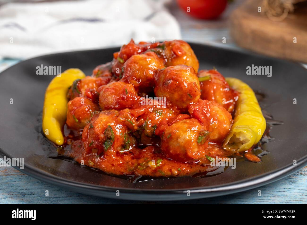 Boulettes de viande d'Alep. Hors-d'œuvre. Petites boulettes de viande avec de la pâte de tomate sur un fond en bois bleu. Gros plan Banque D'Images