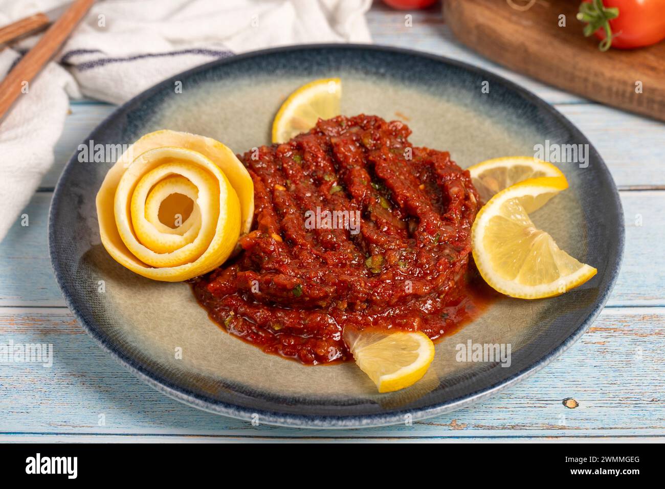 Apéritif épicé. Hors-d'œuvre. Pâté épicé sur fond en bois bleu. nom local acılı ezme. Gros plan Banque D'Images