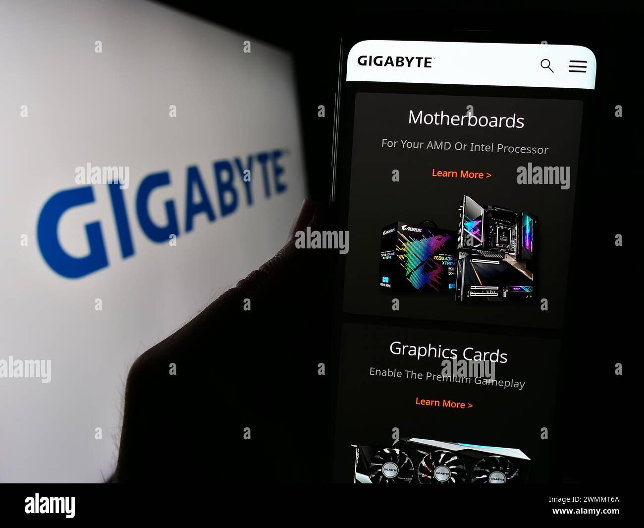 Personne tenant le téléphone portable avec la page Web de la société taïwanaise de matériel informatique Gigabyte Technology avec logo. Concentrez-vous sur le centre de l'écran du téléphone. Banque D'Images