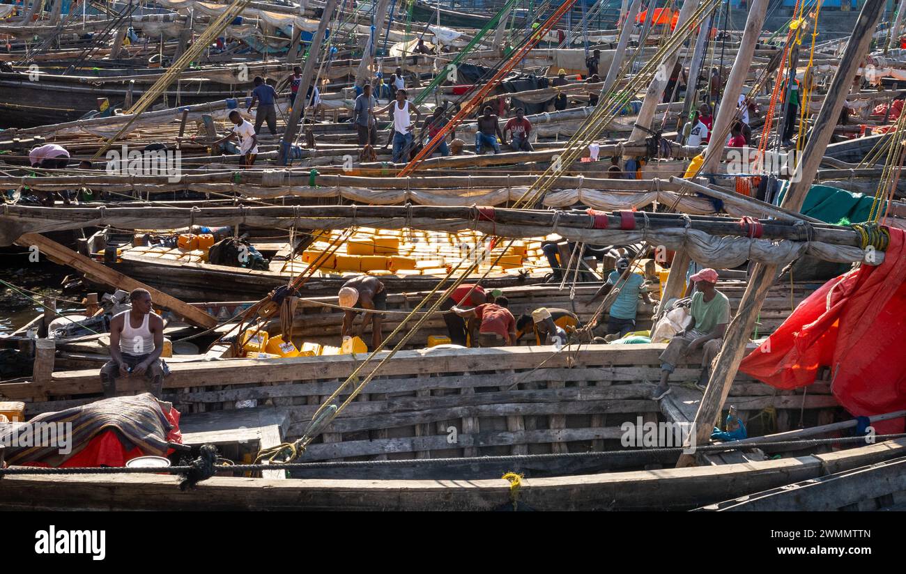 Les pêcheurs travaillent sur des bateaux de pêche en boutre dans le port de Darajani Market, ou le marché aux poissons, à Stone Town, Zanzibar, Tanzanie. Banque D'Images