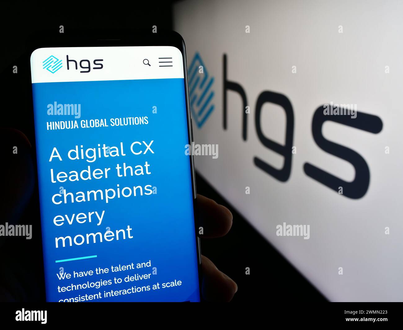 Personne tenant smartphone avec la page Web de la société indienne Hinduja Global solutions Limited (HGS) avec logo. Concentrez-vous sur le centre de l'écran du téléphone. Banque D'Images