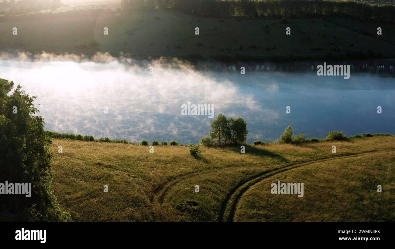 Lac à l'aube en Russie. Lac pittoresque avec brouillard. Lac sauvage un matin brumeux. Banque D'Images