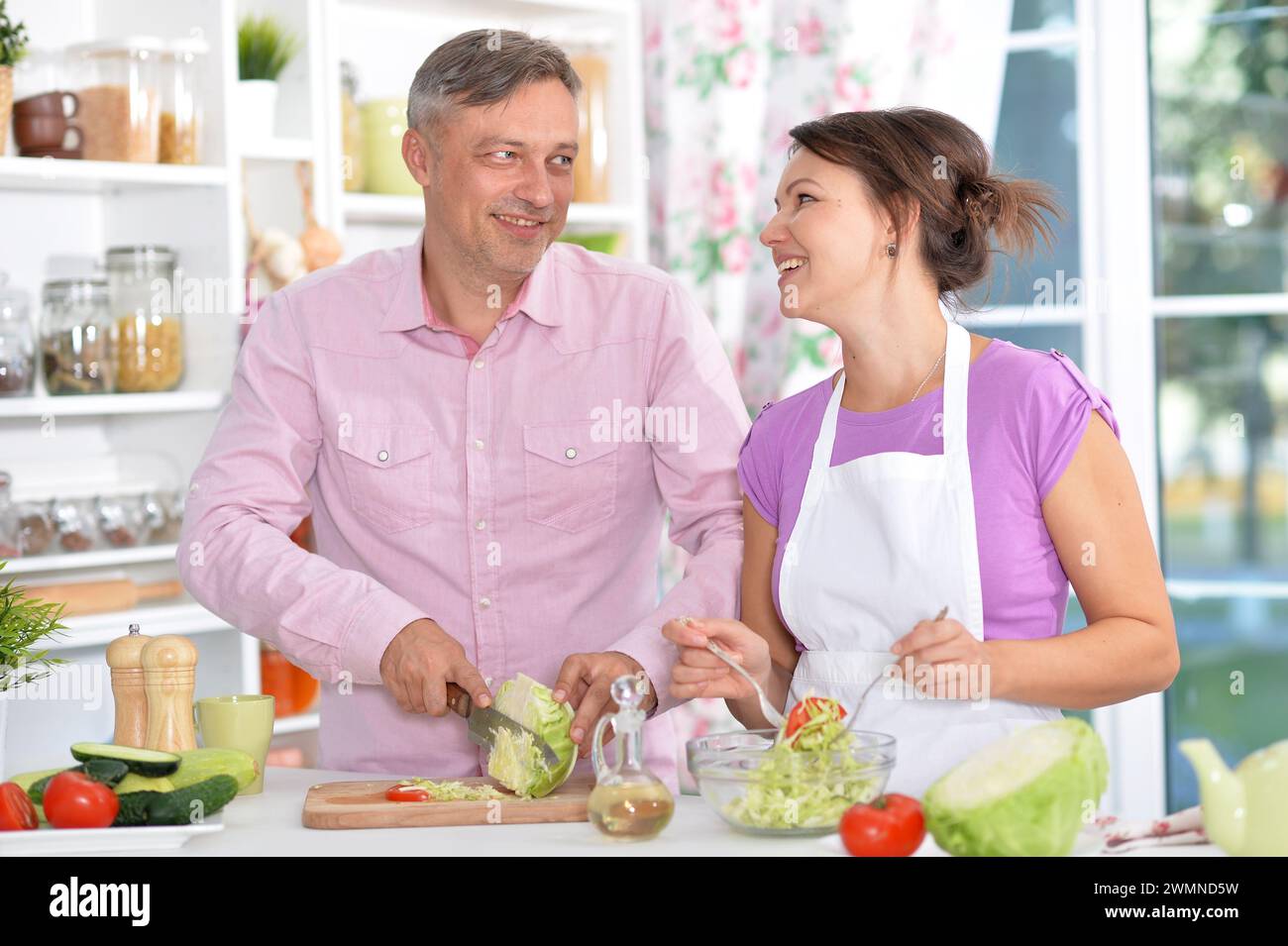 Portrait de couple marié cuisinant à la cuisine Banque D'Images
