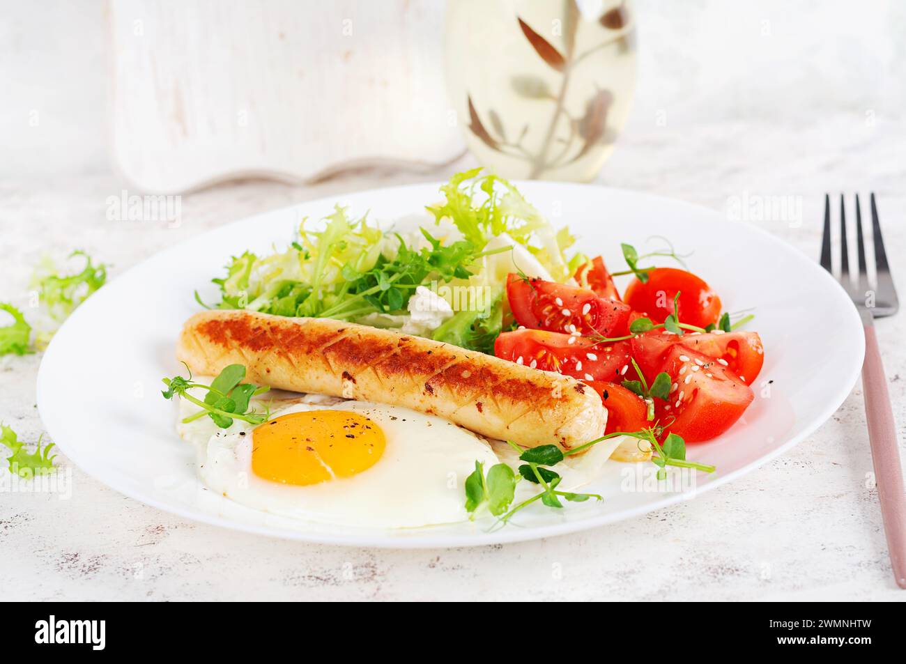Petit déjeuner Keto. Oeuf frit et saucisse de poulet et salade fraîche. Banque D'Images
