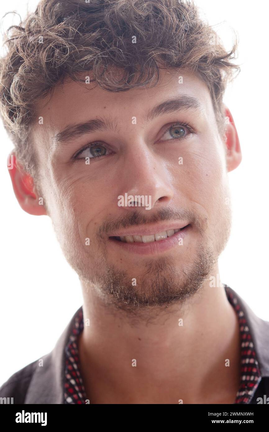 Portrait en gros plan d'un jeune homme souriant regardant vers le haut et sur le côté Banque D'Images