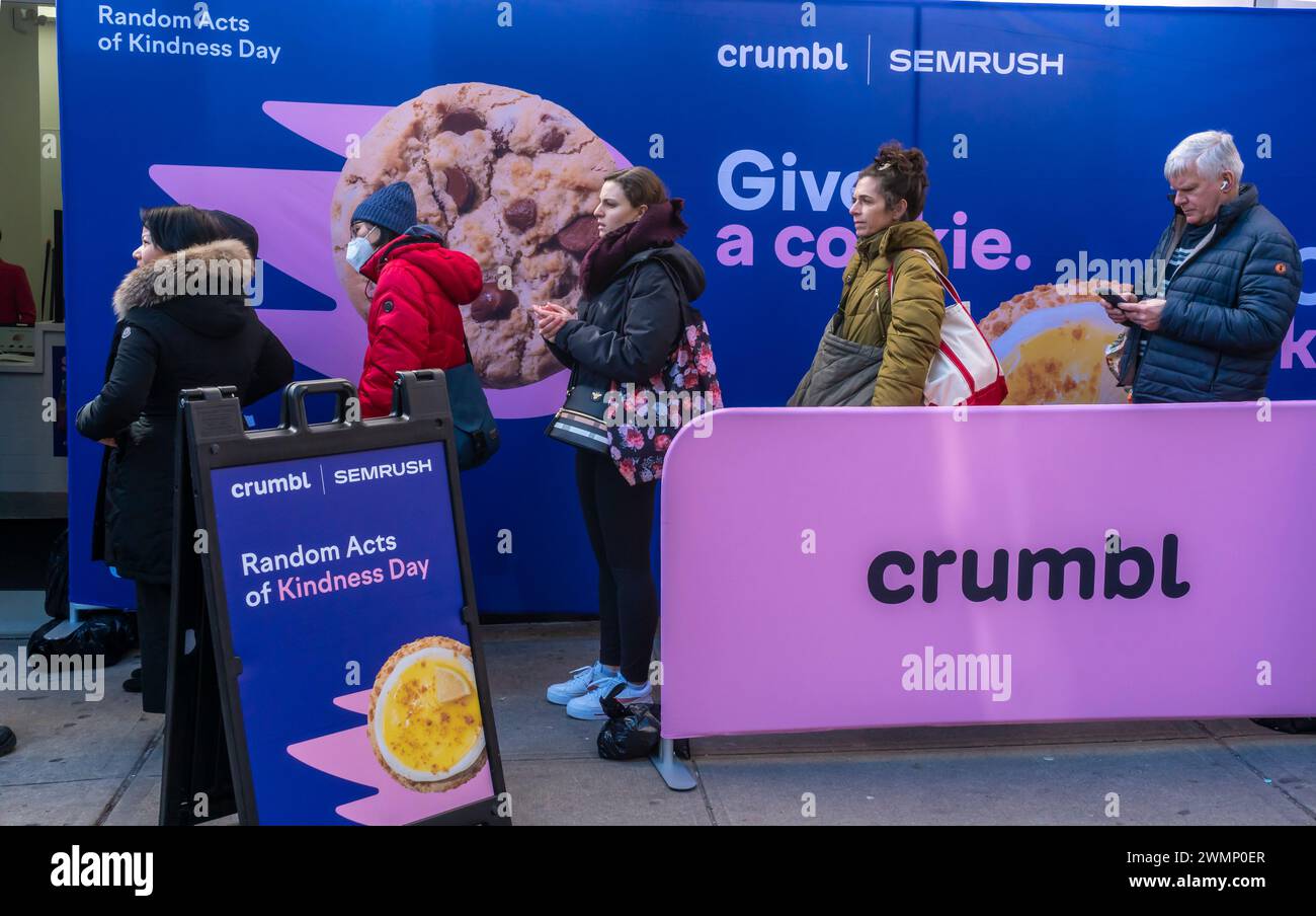 Les amateurs de biscuits se précipitent au magasin Crumbl de Chelsea à New York le vendredi 16 février 2024 pour célébrer le Random Acts of Kindness Day de samedi. En partenariat avec SEMrush, une plateforme d’analyse SaaS, ils distribuent des milliers de cookies, deux pour chaque personne. Les destinataires sont invités à conserver un cookie pour eux-mêmes et à donner l'autre comme un acte de gentillesse aléatoire. (© Richard B. Levine) Banque D'Images