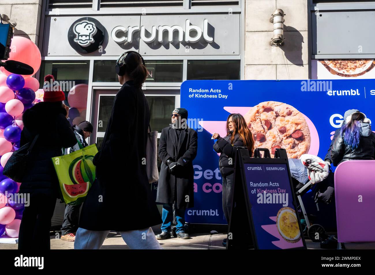 Les amateurs de biscuits se précipitent au magasin Crumbl de Chelsea à New York le vendredi 16 février 2024 pour célébrer le Random Acts of Kindness Day de samedi. En partenariat avec SEMrush, une plateforme d’analyse SaaS, ils distribuent des milliers de cookies, deux pour chaque personne. Les destinataires sont invités à conserver un cookie pour eux-mêmes et à donner l'autre comme un acte de gentillesse aléatoire. (© Richard B. Levine) Banque D'Images