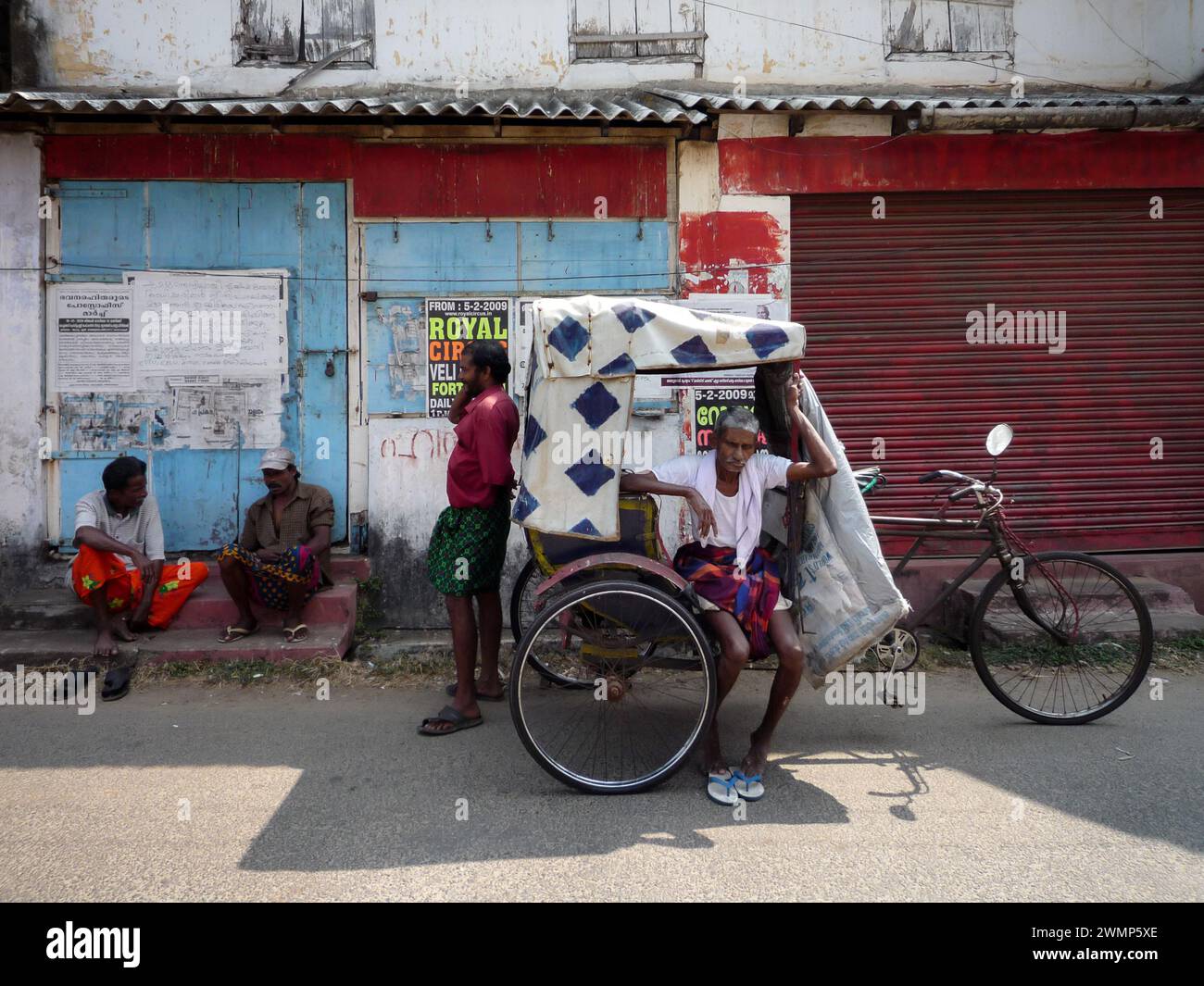 Inde, Kerala, Cochin : un Indien est assis sur son pousse-pousse en attendant de nouveaux passagers Banque D'Images