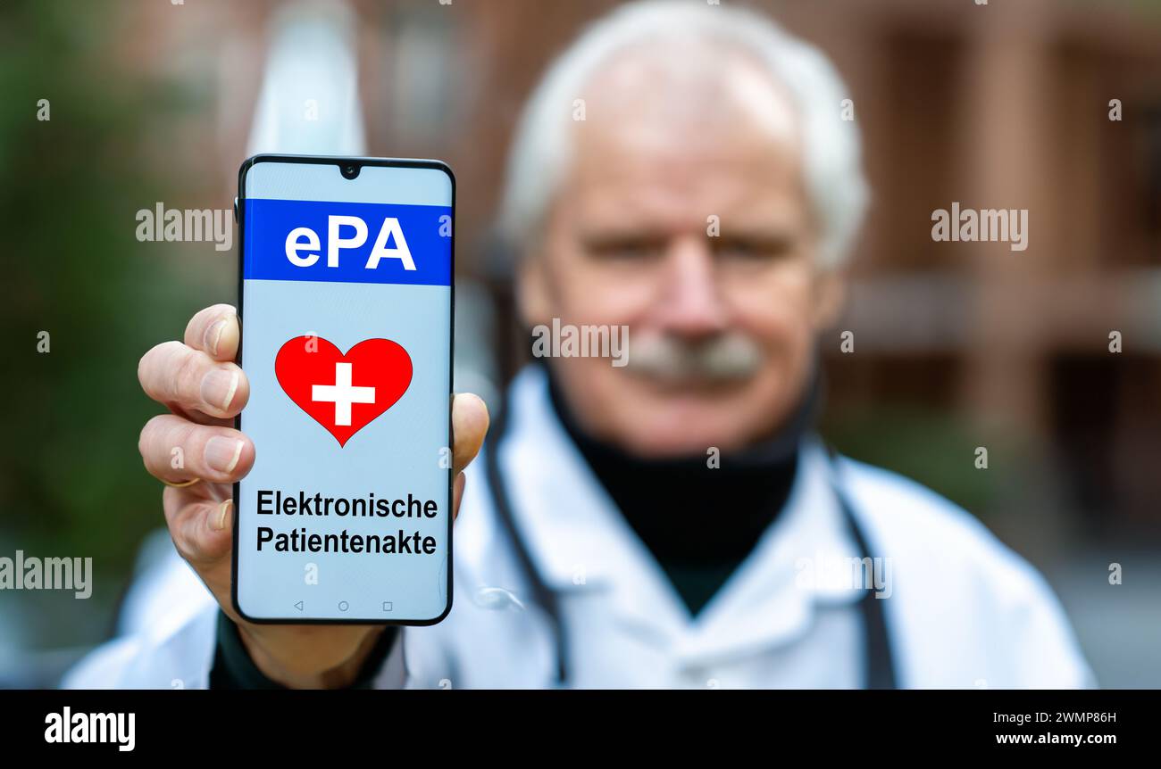 Un médecin tient un téléphone portable avec le texte 'EPA elektrosche Patientenakte' (dossiers médicaux électroniques). Symbole du début de l'électronique h. Banque D'Images