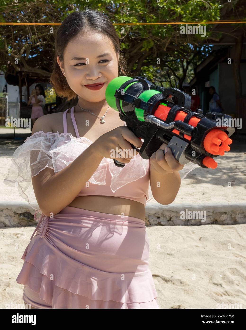 Une fille philippine en maillot de bain avec un pistolet à eau Banque D'Images