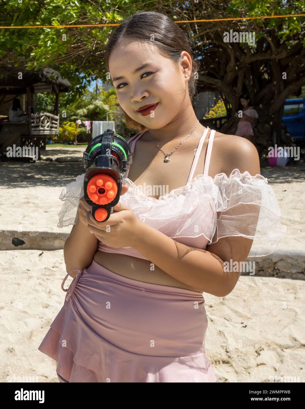 Une fille philippine en maillot de bain avec un pistolet à eau Banque D'Images