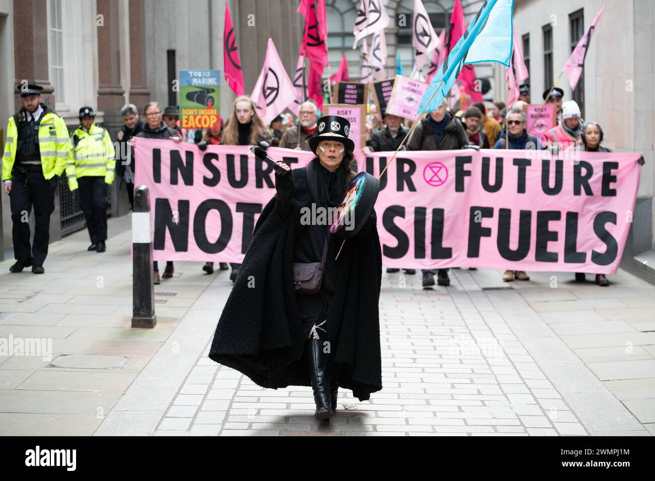 Londres, Royaume-Uni. 27 février 2024. Les activistes climatiques de extinction Rebellion (XR) défilent dans le quartier financier de la ville de Londres pour rendre visite aux compagnies d'assurance et appeler l'industrie à cesser d'assurer de nouveaux projets de combustibles fossiles. Cette action s'inscrivait dans le cadre d'une semaine mondiale d'événements « assurer notre avenir » dans l'espoir de faire pression sur l'industrie pour qu'elle fasse davantage pour lutter contre l'urgence climatique. Crédit : Ron Fassbender/Alamy Live News Banque D'Images