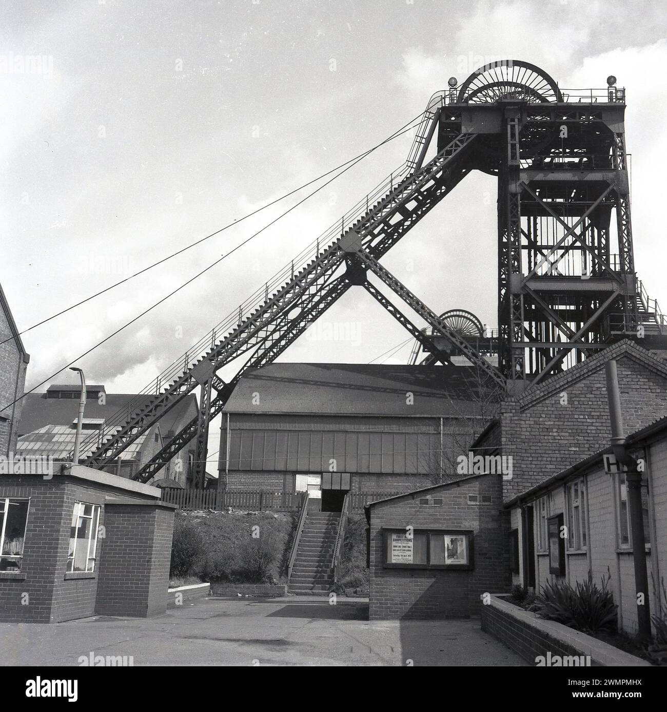 1973, historique, extérieur d'un puits de mine, montrant la tête en acier au-dessus du sol ou la tour d'enroulement, Sheffield, Angleterre, Royaume-Uni. Une affiche dans la fenêtre du bureau minier dit, concours de premiers secours, région de Doncaster, finale junior et senior à la Don Valley High School, Sheffield. Banque D'Images