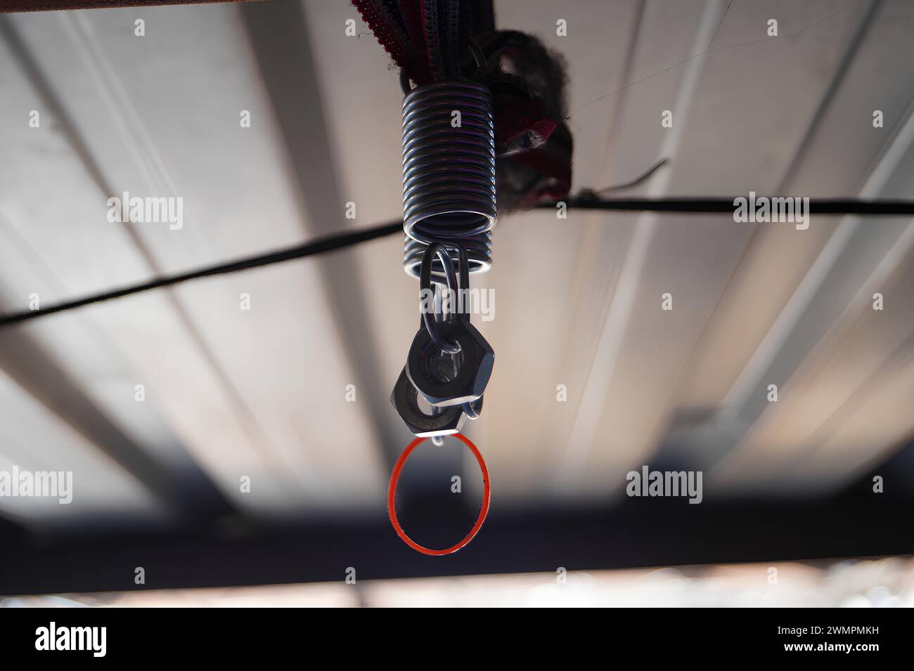 Vue rapprochée d'un ressort métallique et d'un clip attaché à un fil à l'intérieur Banque D'Images