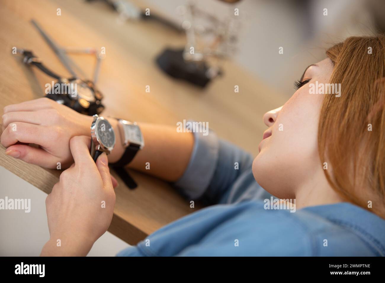réparateur de montres féminin comparant les visages sur deux montres Banque D'Images