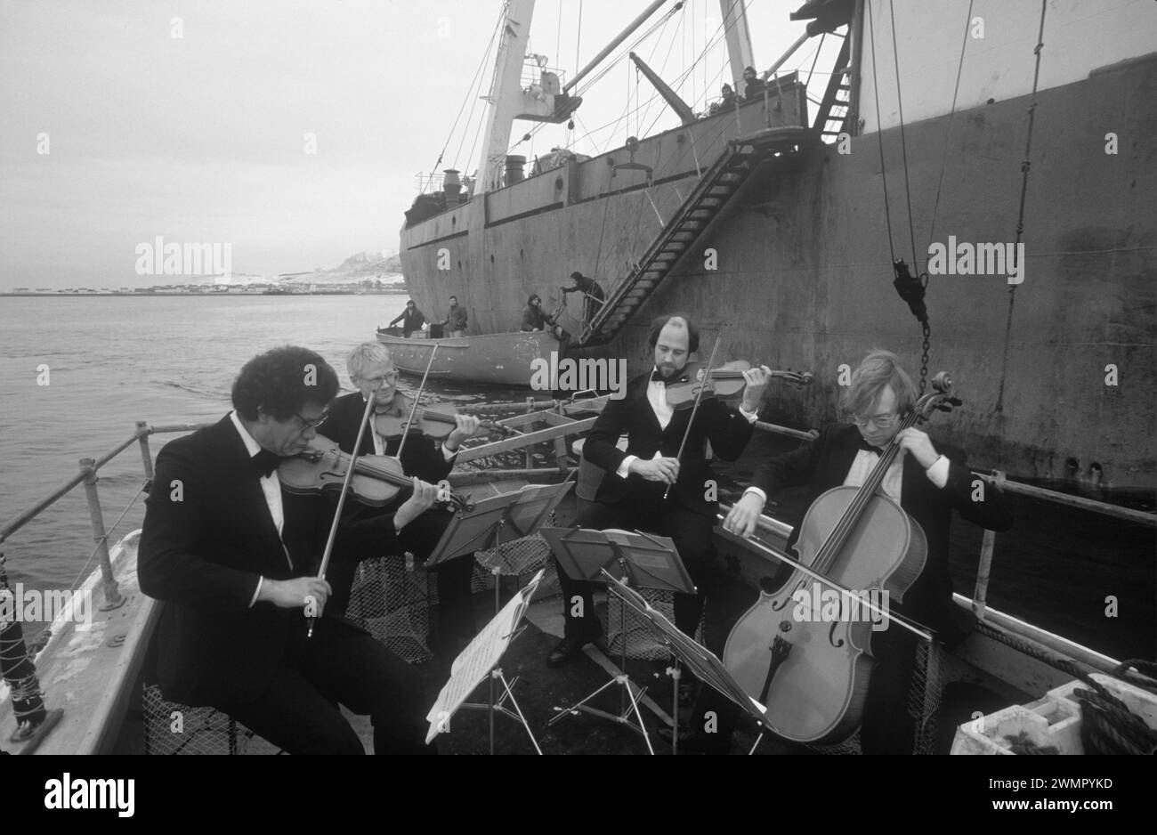 Le quatuor à cordes d'Édimbourg joue dans le Loch Broom pour les chalutiers de pêche de l'usine d'Europe de l'est en tant qu'acte d'amitié. Loch Broom, Ullapool, Écosse années 1986 1980 Royaume-Uni HOMER SYKES Banque D'Images