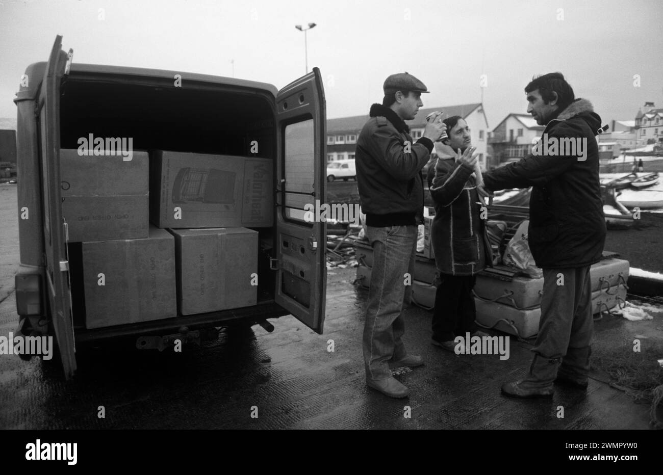 Klondykers – pêcheurs d’Europe de l’est – en congé de terre, ils travaillent sur des bateaux de pêche d’usine sur le Loch Broom, Ullapool. Les deux hommes à droite sont des pêcheurs négociant avec un local – Dellboy – qui possède une camionnette pleine de radiateurs et d’autres appareils électriques qu’il espère vendre. Les chalutiers étaient très désireux d'acheter des produits électriques pour les ramener chez eux. Ullapool, Écosse années 1986 1980 Royaume-Uni HOMER SYKES Banque D'Images