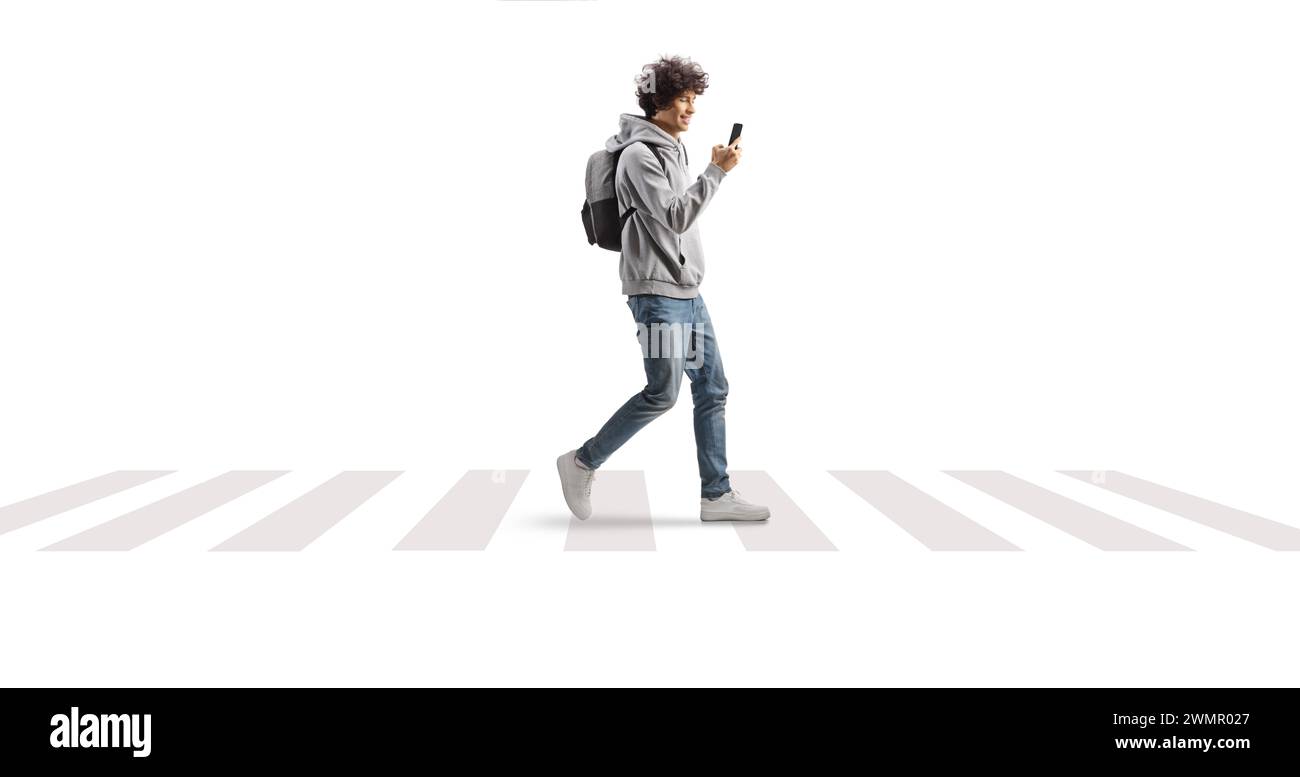 Étudiant portant un sac à dos et marchant à un passage pour piétons avec un smartphone dans ses mains isolé sur fond blanc Banque D'Images