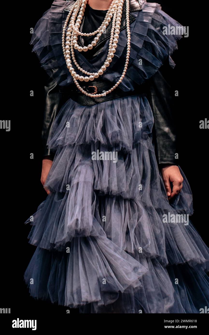 Robe en satin bleu avec volants et perles de perles sur fond noir. Look élégant et tendance Banque D'Images