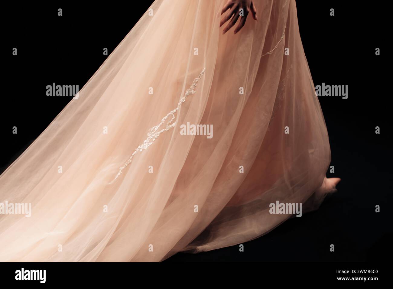 Élégante robe chic beige longue soirée sur fond noir. Vêtements de mode féminins Banque D'Images