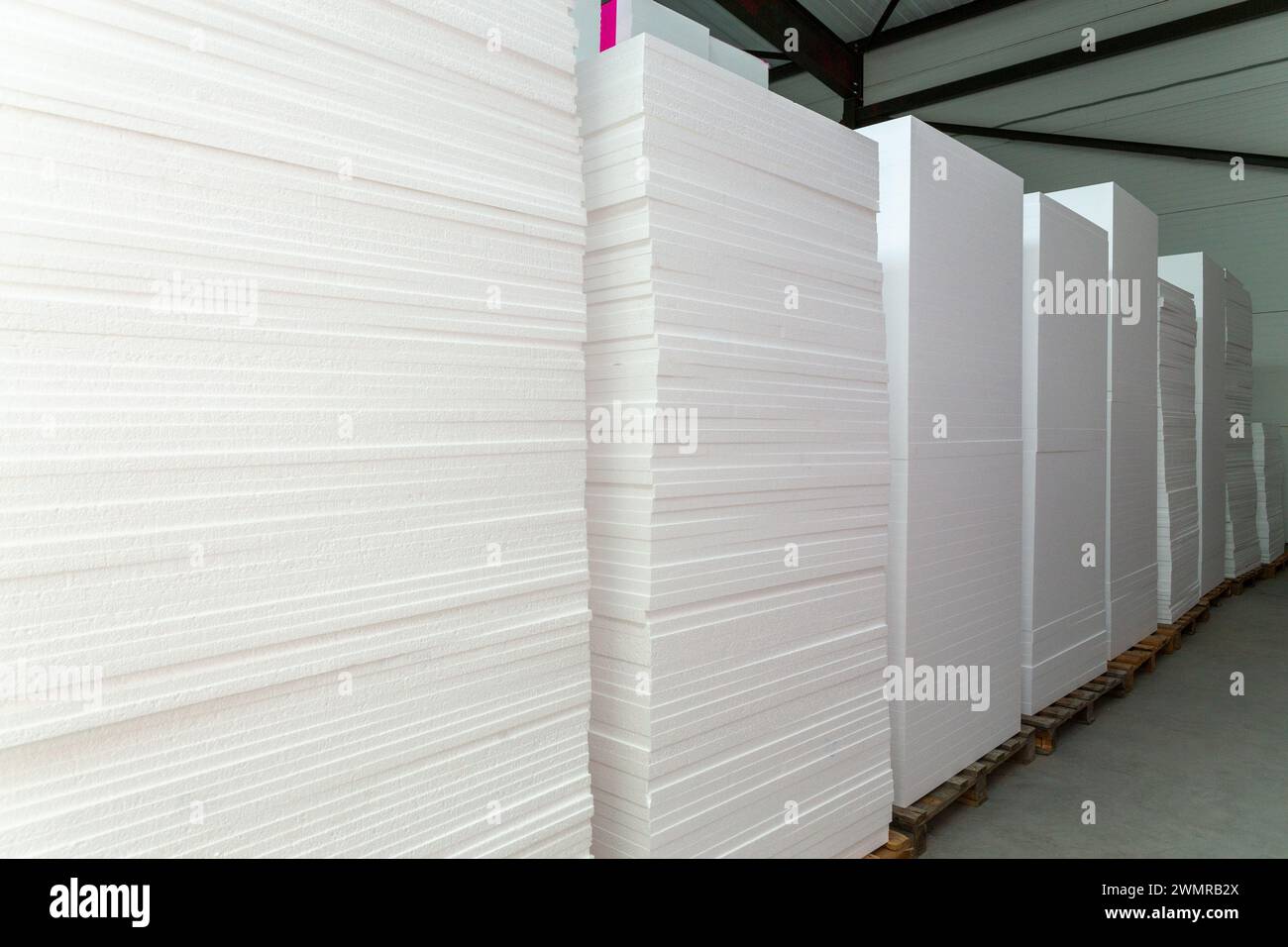 De grands blocs de polystyrène sont empilés dans un entrepôt. Production industrielle de panneaux ou plaques isolants en mousse de polystyrène à partir de polystyrène expansé Banque D'Images