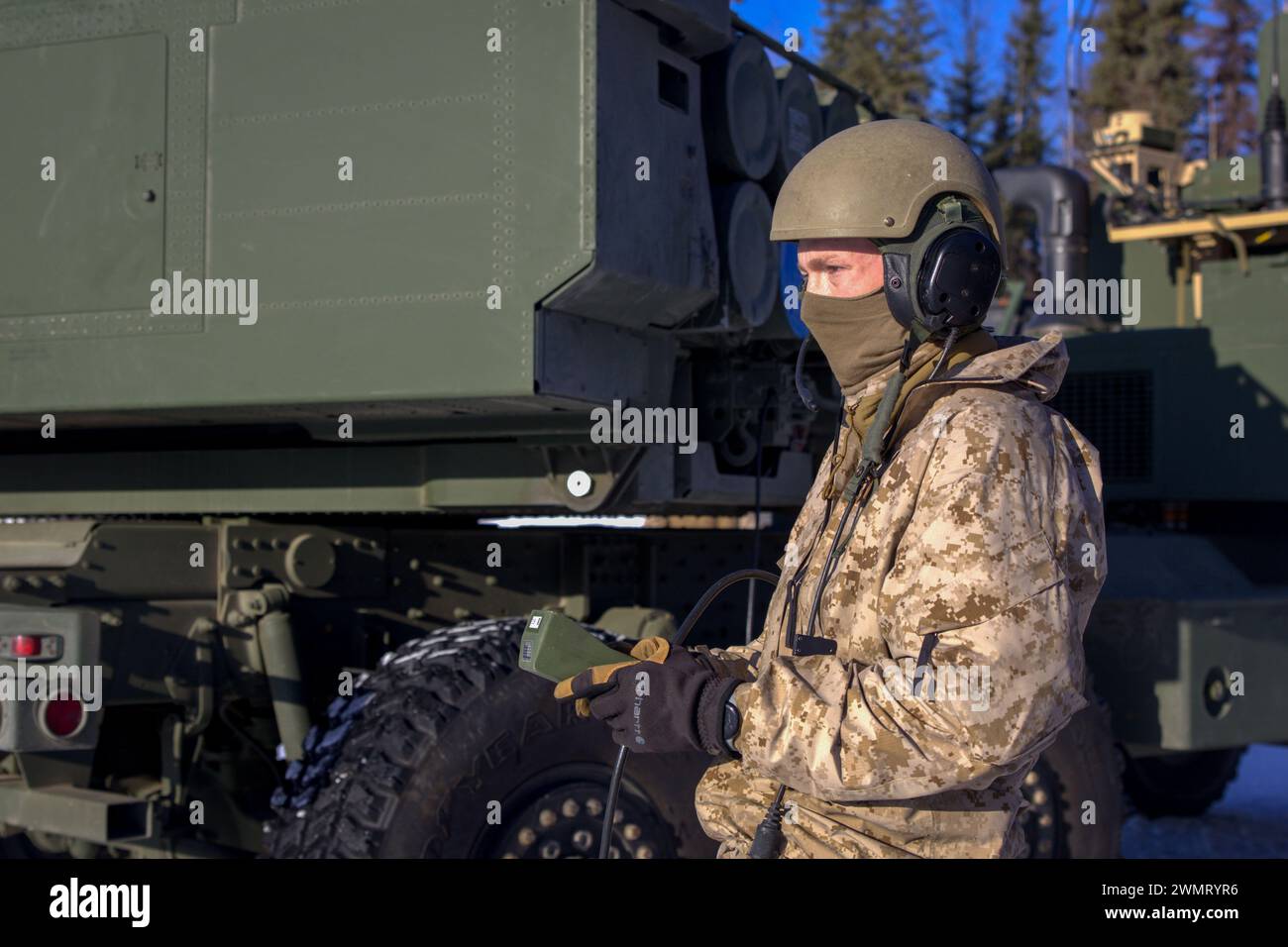 Un Marine américain avec Fox Battery, 2nd Battalion, 14th Marine Regiment, 4th Marine Division, Marine Forces Reserve effectue un rechargement simulé sur un High Mobility Artillery Rocket System (HIMARS) lors de l'exercice Arctic Edge 2024 à la base aérienne d'Eielson, Alaska, le 23 février 2024. Dans le cadre des capacités de la Marine Air-Ground Task Force (MAGTF), le système d'armes HIMARS contribue de manière significative à la projection de puissance et à l'appui-feu de précision de la MAGTF pour les Marines dans divers scénarios, y compris ceux dans un environnement arctique, améliorant ainsi l'efficacité et la polyvalence globales. Arctic Edge 2024 (AE24) i Banque D'Images