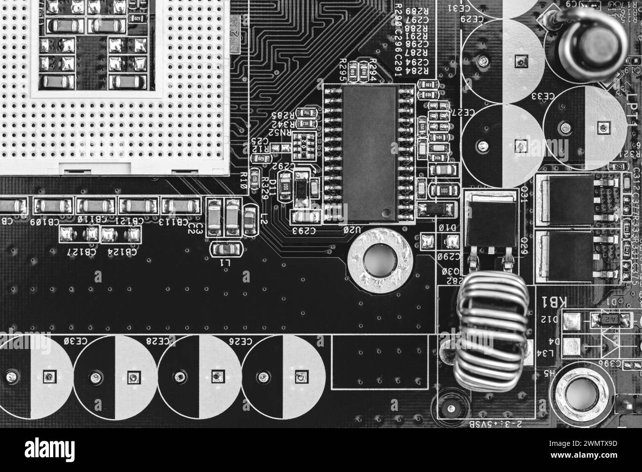 gros plan sur la carte de circuit imprimé avec des résistances, des condensateurs, des micropuces et des composants électroniques. b/w. Banque D'Images
