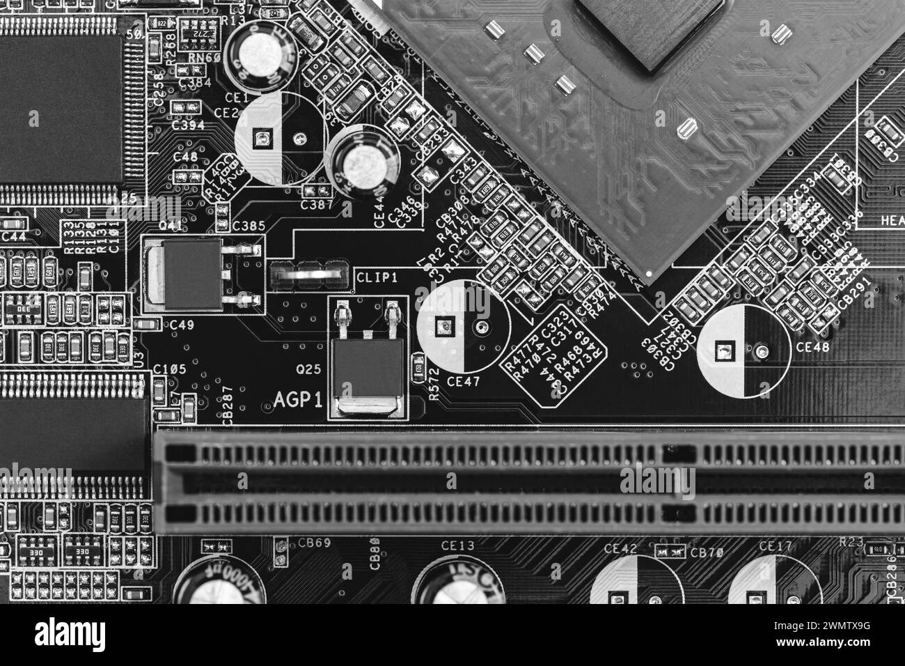 gros plan sur la carte de circuit imprimé avec des résistances, des condensateurs, des micropuces et des composants électroniques. b/w. Banque D'Images