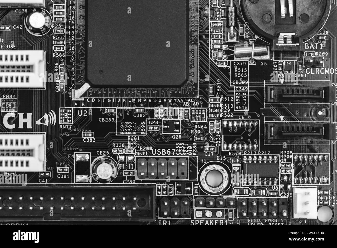 gros plan sur la carte de circuit imprimé avec des résistances, des condensateurs, des micropuces et des composants électroniques. b/w. Banque D'Images