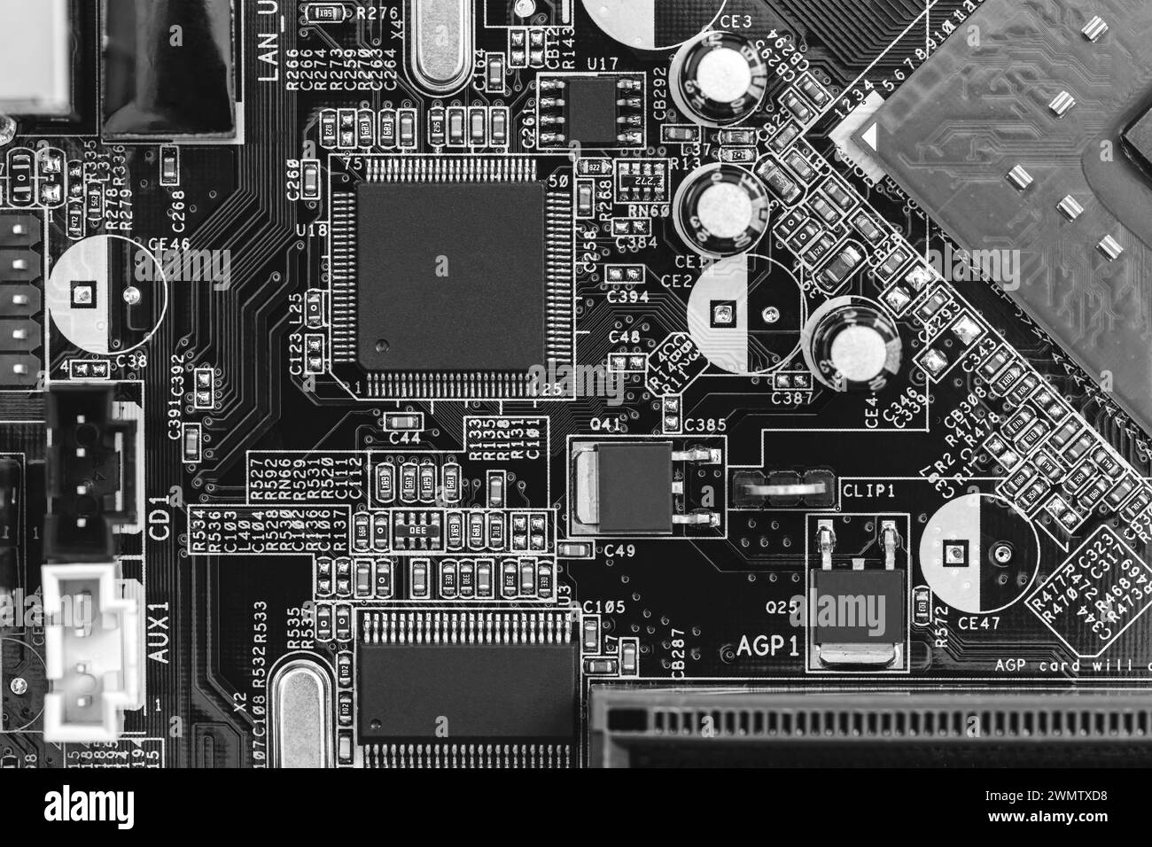 gros plan sur la carte de circuit imprimé avec des résistances, des condensateurs, des micropuces et des composants électroniques. b/w. Banque D'Images