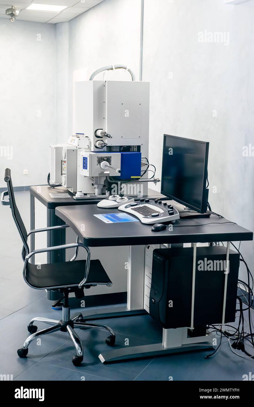 Espace de travail d'un scientifique avec microscope électronique, table et ordinateur Banque D'Images