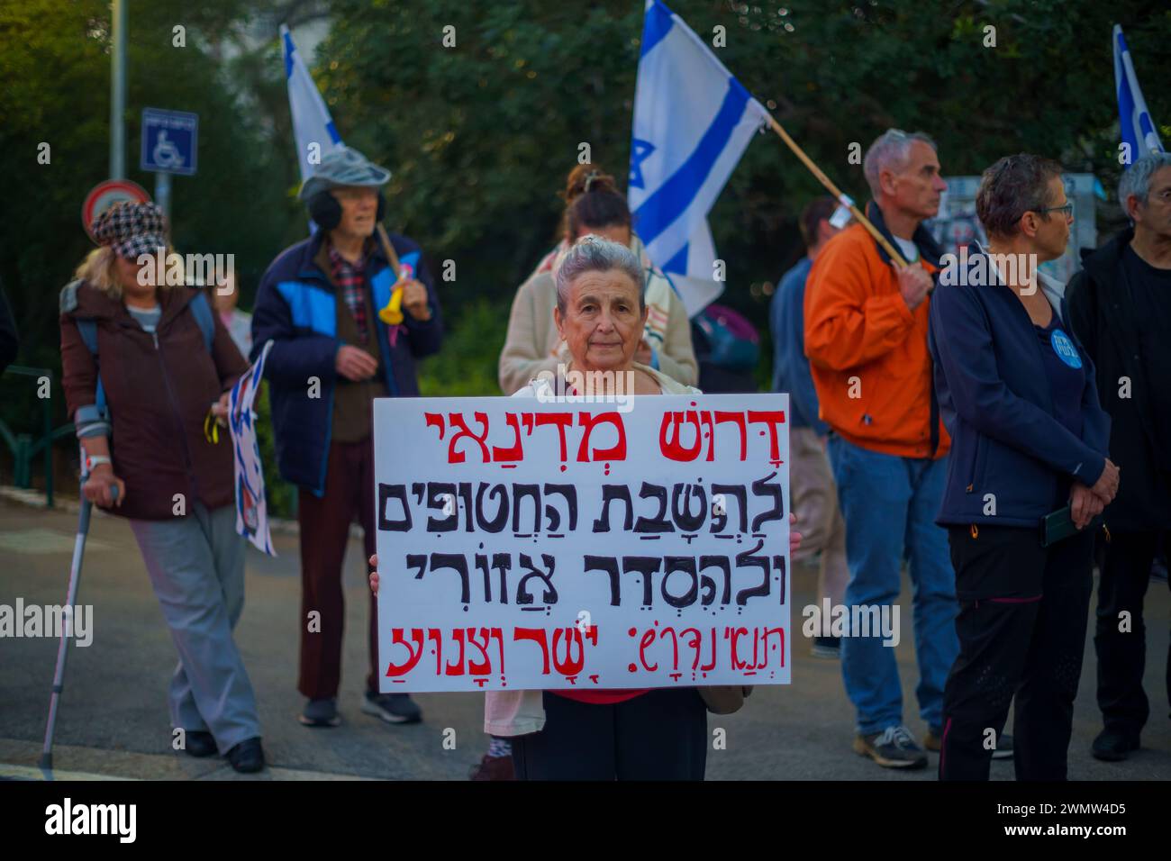 Haïfa, Israël - 24 février 2024 : des personnes portant divers signes et drapeaux protestent contre le gouvernement, appelant à prendre la responsabilité de la guerre Banque D'Images