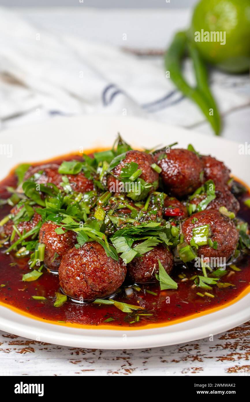 Boulettes de viande d'Alep. Saveurs asiatiques traditionnelles. Boulettes de viande avec pâte de tomate. Boulettes de viande d'Alep sur fond de bois blanc. Gros plan Banque D'Images