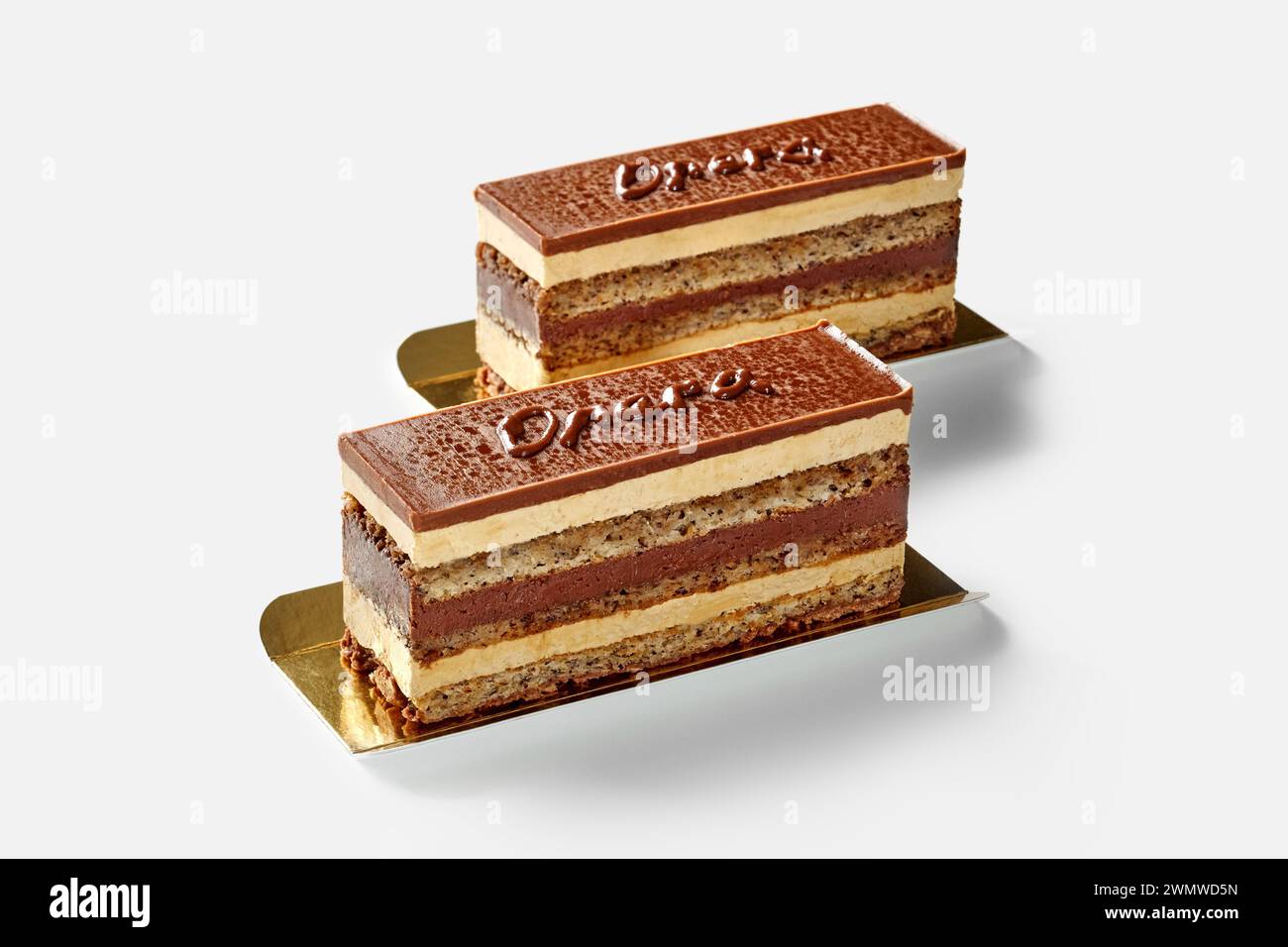 Tranches de gâteau avec des couches de pâte éponge de noix imbibées de sirop de café, de ganache au chocolat et de crème au beurre, avec le mot Opera écrit sur le glaçage au chocolat, Banque D'Images