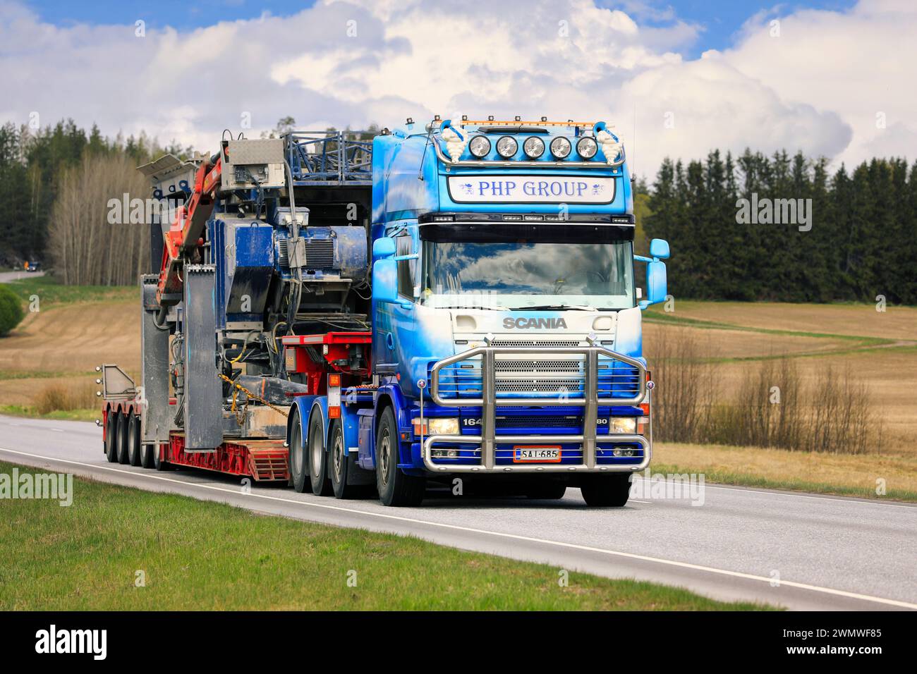 Personnalisé Scania 164 camion semi-remorque PHP Group Oy transporte l'équipement de concassage comme charge surdimensionnée le long de l'autoroute 52. Salo, Finlande. 13 mai 2022. Banque D'Images