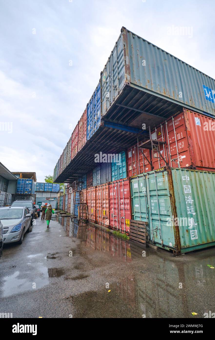 Une vue typique des nombreux vieux conteneurs d'expédition empilés, réutilisés, utilisés pour le stockage, les entreprises. Au marché local des conteneurs maritimes de Barakholka i Banque D'Images