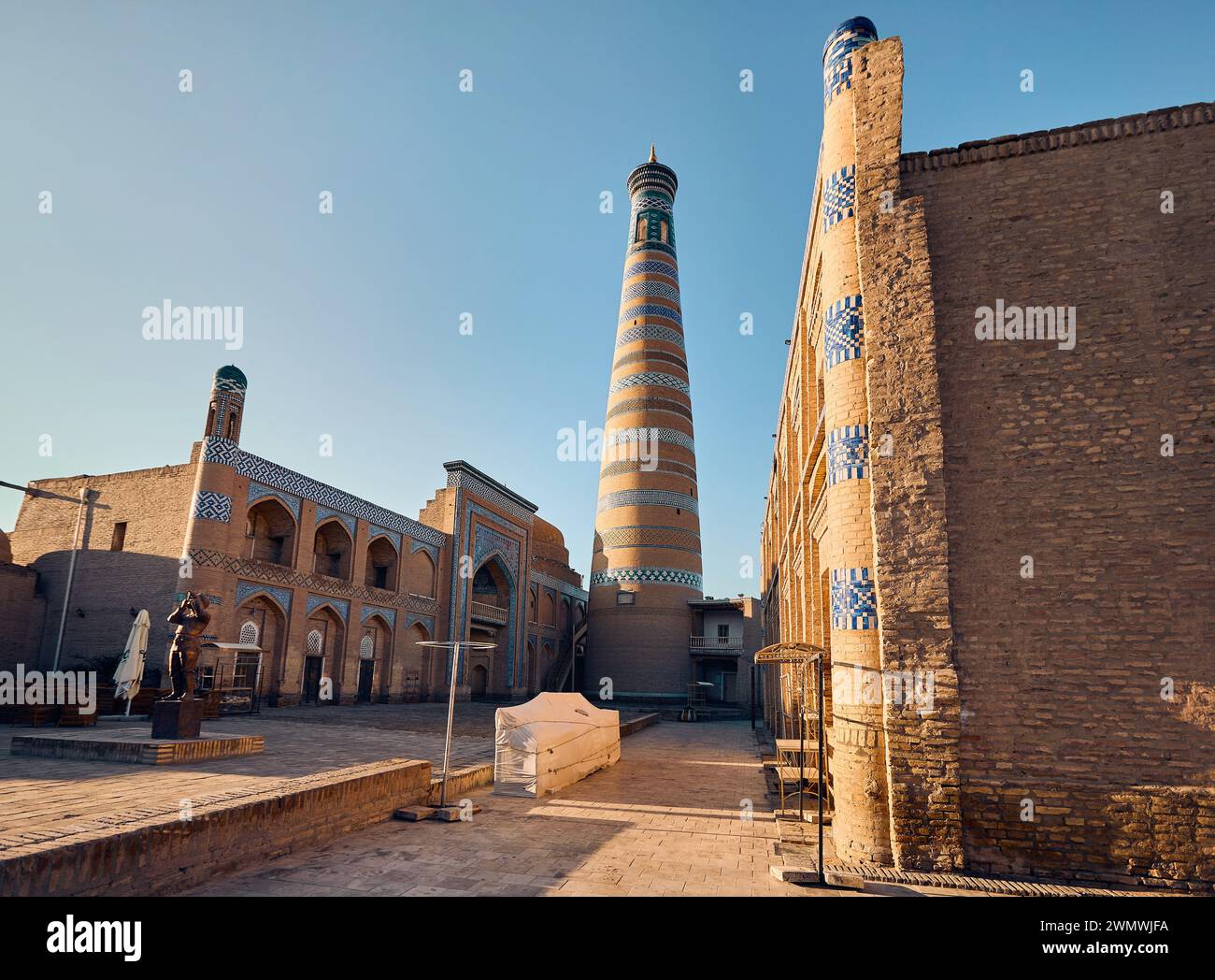 Place publique avec statue de flûtiste et minaret à Ichan Kala de Khiva en Ouzbékistan Banque D'Images