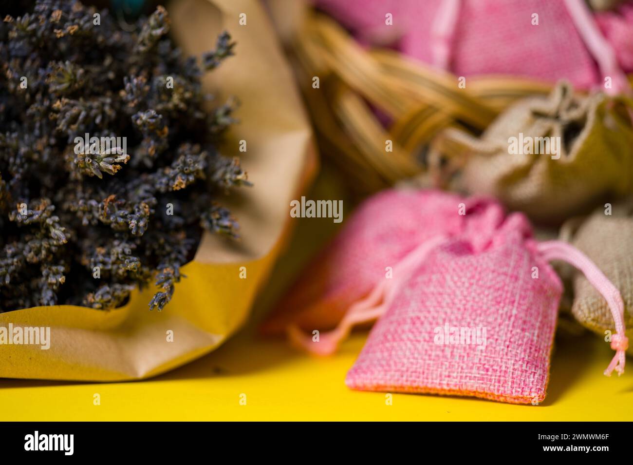 Fleurs de lavande séchées et sachets sur fond jaune, aromathérapie à la lavande. Banque D'Images