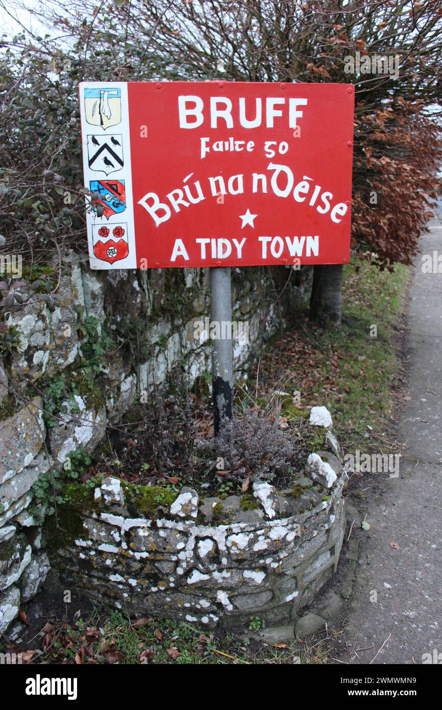 Un panneau de bienvenue en Irlande rurale sur le côté du roa écrit en gaélique irlandais. Signe accueillant les gens à Bruff, comté de Limerick, Irlande - une ville bien rangée Banque D'Images
