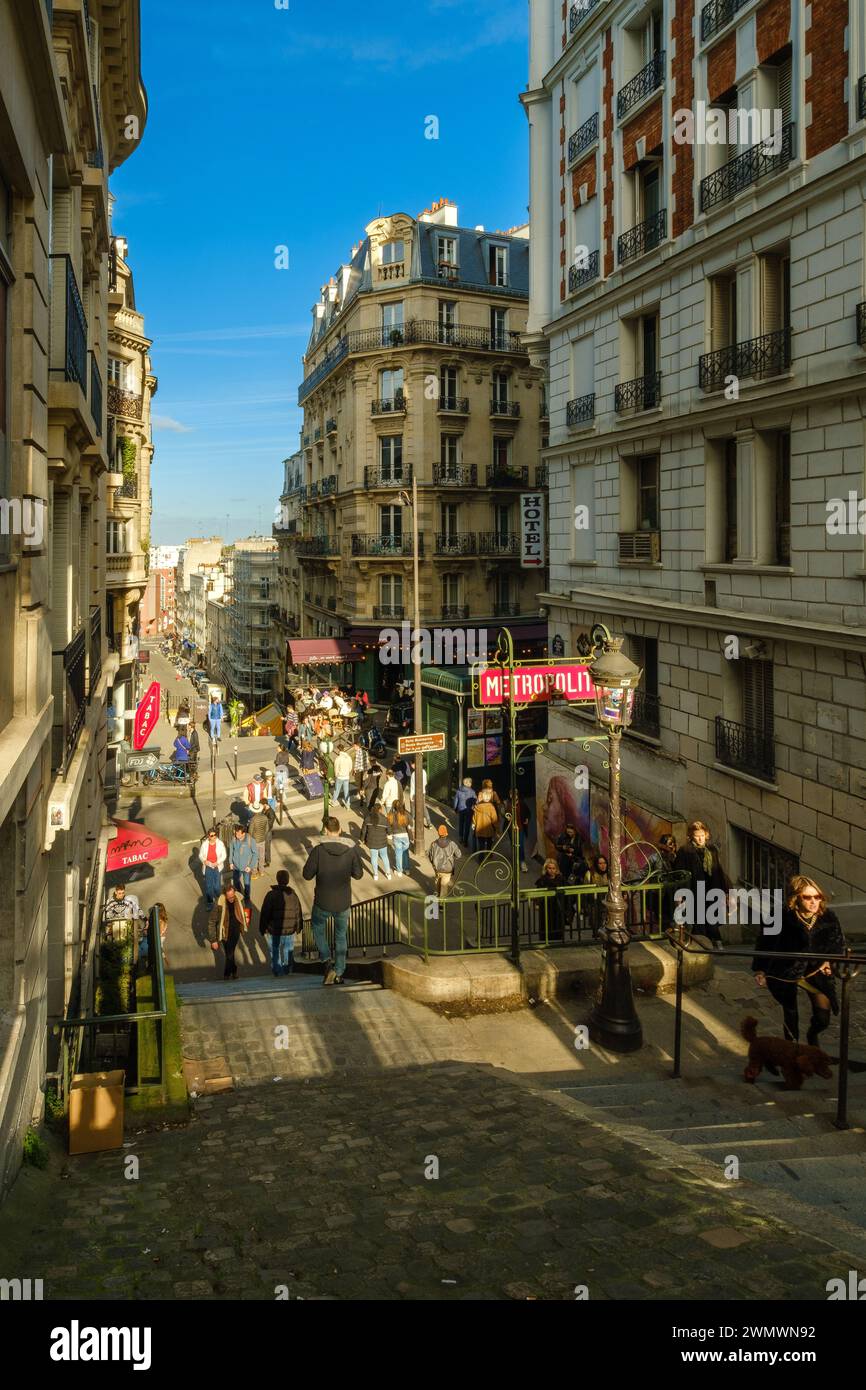 Paris, France - 17 février 2024 : vue des marches menant à une station de métro pittoresque et à un café typiquement français dans le quartier de Montmartre à Paris Banque D'Images