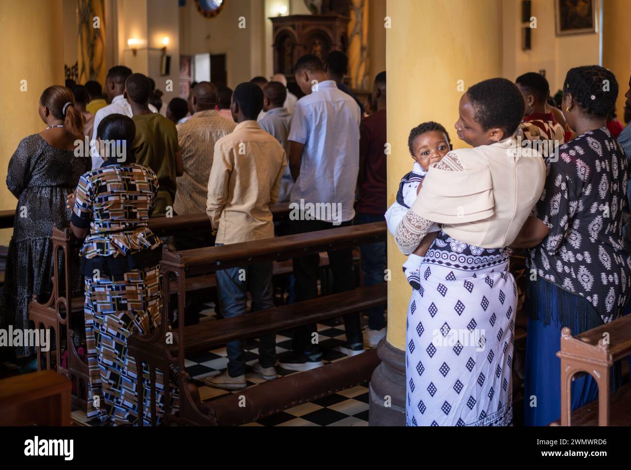 Une mère de la congrégation câlin son bébé à la messe catholique du dimanche dans la cathédrale Saint-Joseph, Stone Town, Zanzibar, Tanzanie Banque D'Images