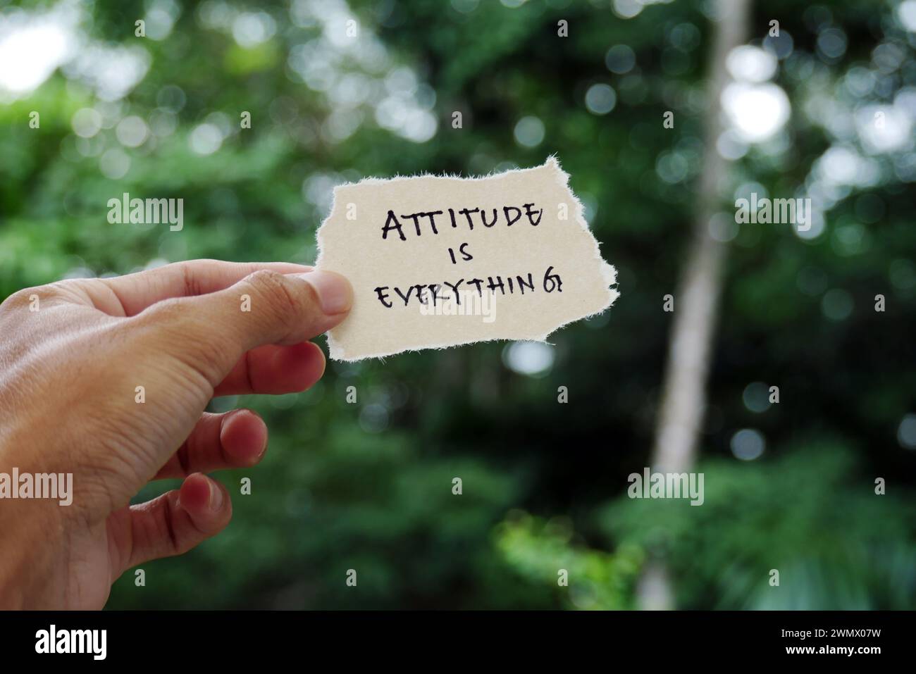 Attitude is Everything - main tenant le papier déchiré slogan motivationnel typographie inspiratoire citation sur papier déchiré Banque D'Images