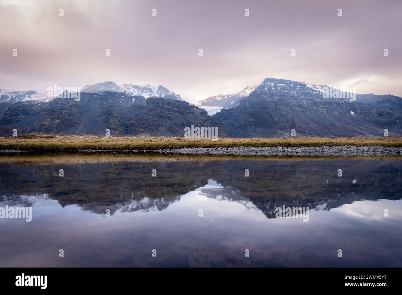 Une vue panoramique sur les montagnes reflétée dans une grande masse d'eau. Islande Banque D'Images