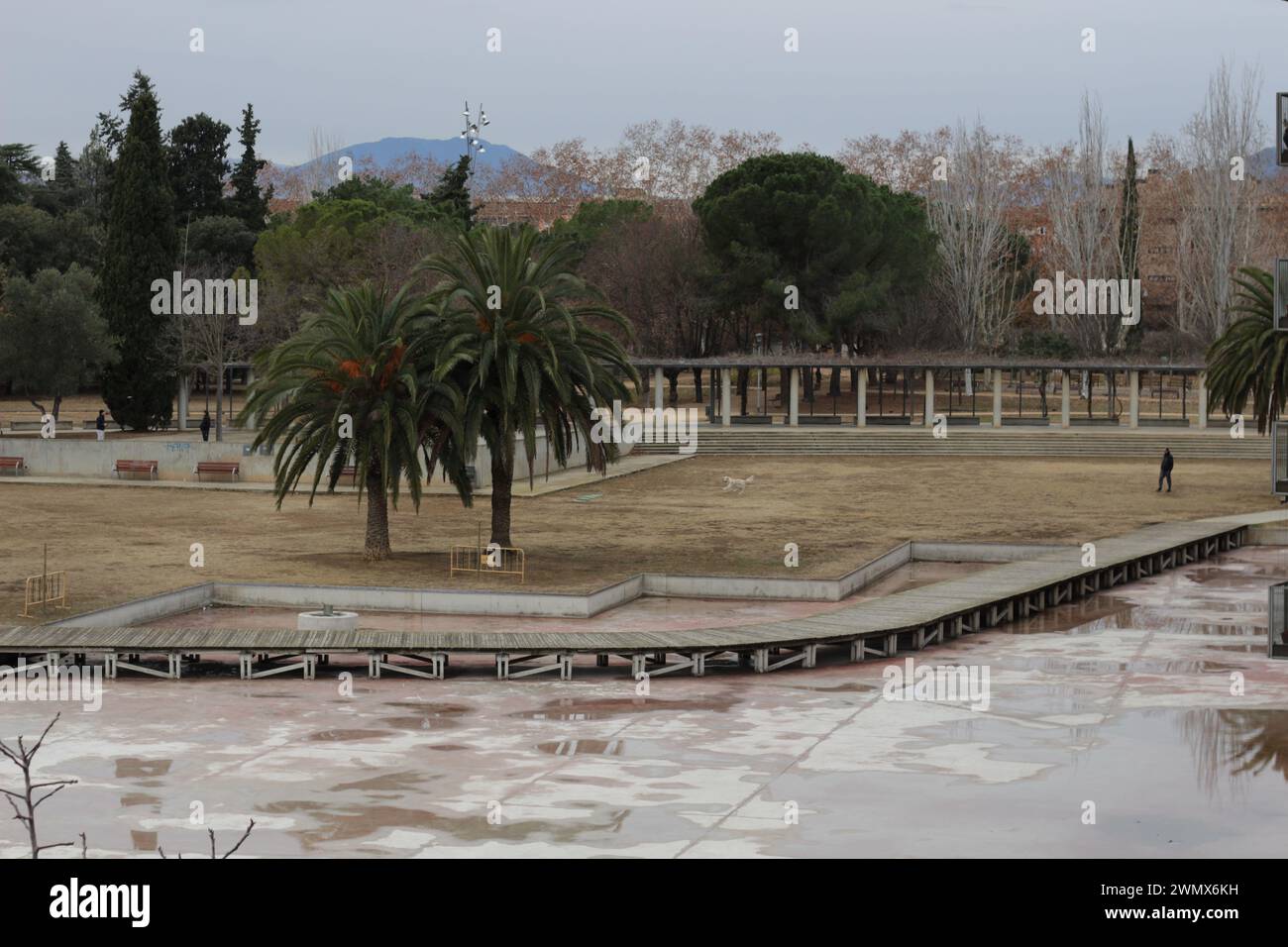 Une image frappante du Parc Migdia à Gérone pendant la sécheresse catalane, mettant en valeur un paysage desséché où une végétation luxuriante prospérait autrefois. Le lit sec du lac Banque D'Images