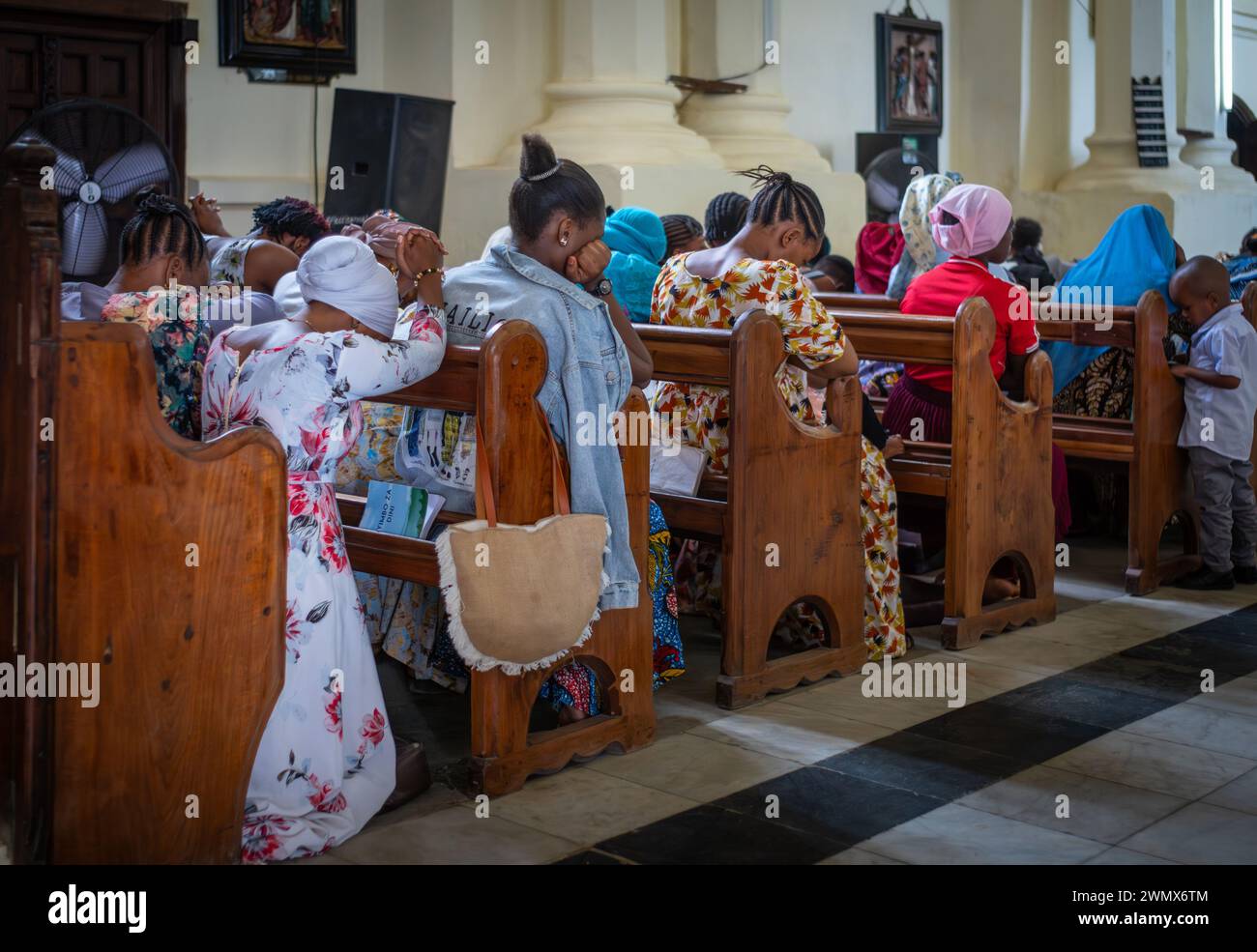 Des femmes vêtues de robes colorées prient lors du service du dimanche dans la cathédrale anglicane Christ Church de Stone Town, Zanzibar, Tanzanie. Banque D'Images