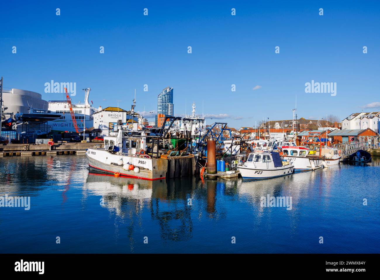 Petits bateaux de pêche locaux amarrés à Camber Quay dans le vieux Portsmouth, Hampshire, une station balnéaire sur le Solent sur la côte sud de l'Angleterre par une journée ensoleillée Banque D'Images